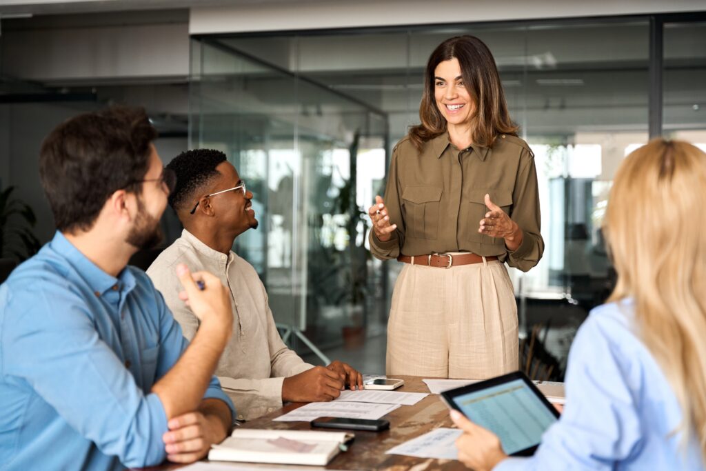 Happy middle aged business woman executive ceo leader discussing project management planning strategy